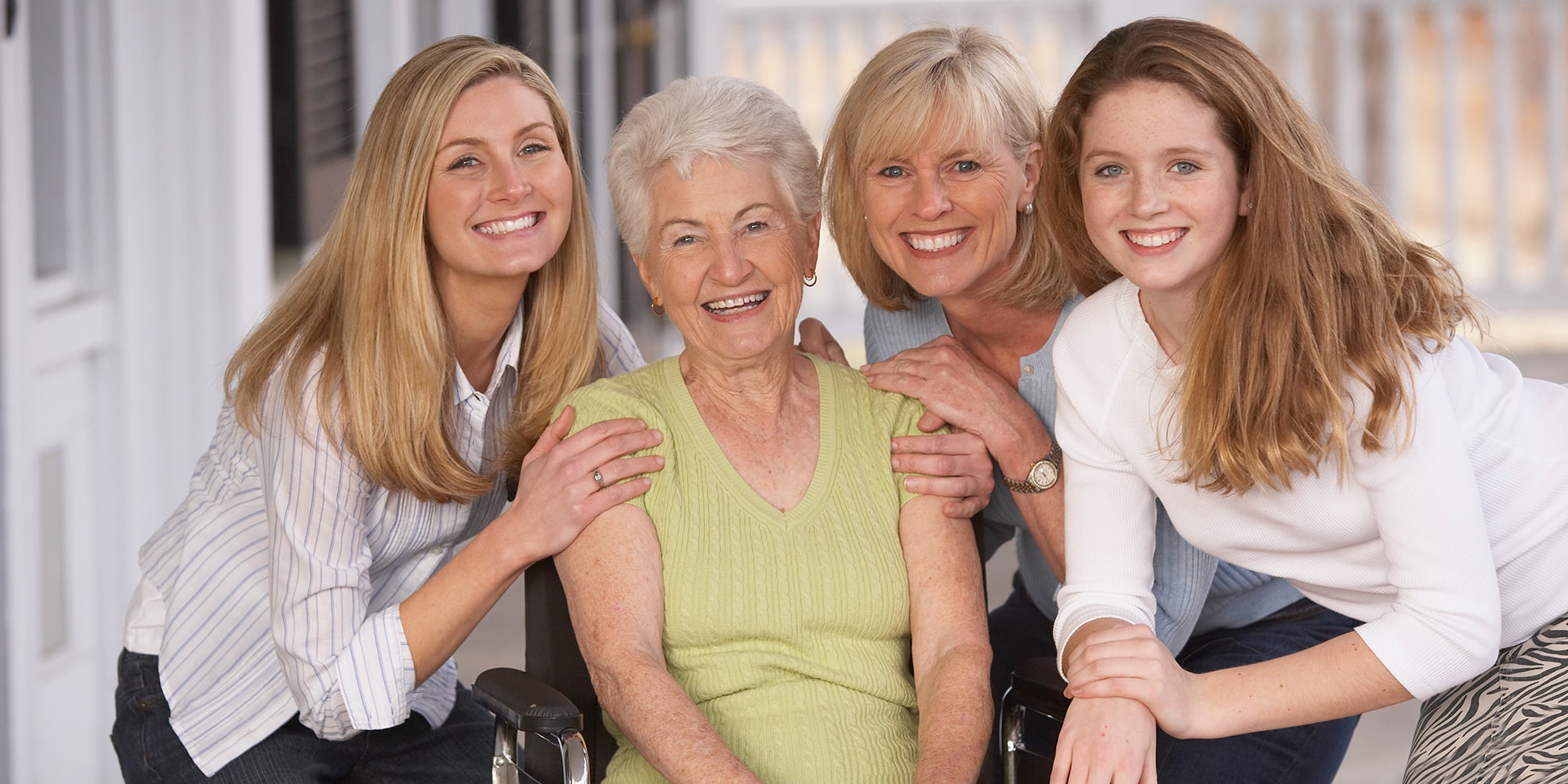 A family outside in a group smiling together.