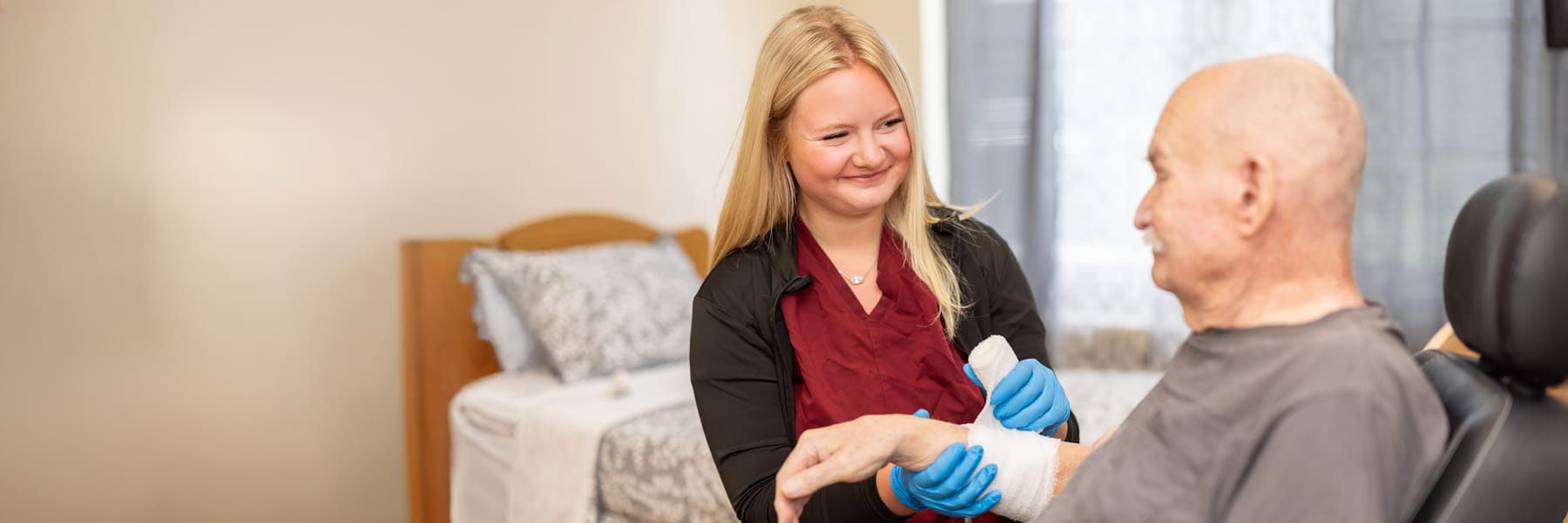 Nurse wrapping bandage on patient's arm at Eagle Ridge Post Acute